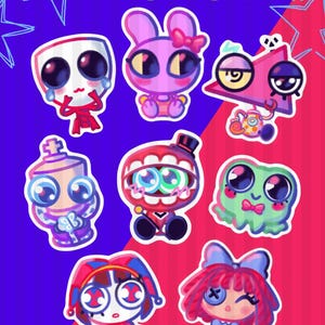 Op de afbeelding: Een verzameling van acht kleurrijke cartoonstickers met diverse expressieve ontwerpen, waaronder een masker, een konijn, een driehoek, een schaakstuk, een mond, een groen wezen, een nar en een pop, met de tekst NEW TADC STICKERS !!