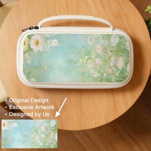 May include: A white carrying case with a floral design. The case features a handle and a zipper closure. The artwork on the case depicts a pastel-colored garden scene with white and pink flowers against a light blue background. The text on the image says "Original Design", "Exclusive Artwork", and "Designed by Us".