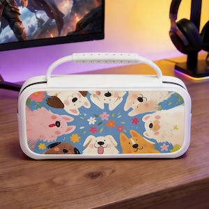 Pode incluir: Estojo de transporte retangular branco com uma alça, apresentando uma ilustração colorida de vários cães de desenho animado em um fundo azul com flores. A alça e o zíper são brancos.