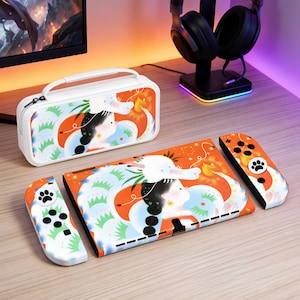 Pode incluir: Uma mala de transporte branca, uma consola e dois comandos com um design a condizer. O design apresenta um dragão branco, uma mulher e detalhes em laranja e azul. Os comandos têm um design de pegada.