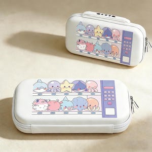Op de afbeelding: Twee witte etuis met een automaatontwerp. Elke etui heeft een kleurrijke reeks cartoonzeedieren, waaronder dolfijnen, octopussen en zeesterren. De etuis hebben een ritssluiting en een handvat.