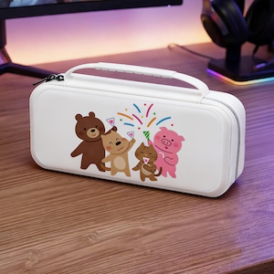 Pode incluir: Uma capa de transporte branca com uma alça e fecho de correr. A capa apresenta uma ilustração colorida de um urso, um gato, um porco e um urso celebrando com confetes. A capa foi concebida para proteger dispositivos eletrónicos.