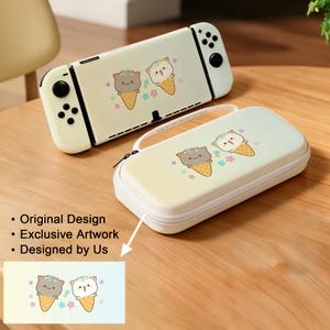 May include: Cream-colored Nintendo Switch console and matching carrying case. Both feature a whimsical design of cat-shaped ice cream cones with pastel accents. The case has a zipper closure and a handle. The text on the image says: Original Design, Exclusive Artwork, Designed by Us.