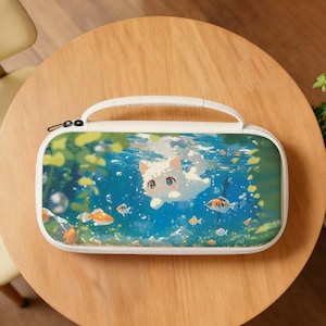 May include: White carrying case with a handle, featuring a cartoon illustration of a white cat swimming underwater with fish. The case has a white zipper and a white handle. The background is blue with green plants.
