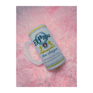 Peut inclure: Un grand mug &agrave; bi&egrave;re blanc avec le texte "El Papa" et "Mas chingon" en bleu et or. Le mug a une anse et est d&eacute;cor&eacute; d'un blason et des mots "Imported Beer".