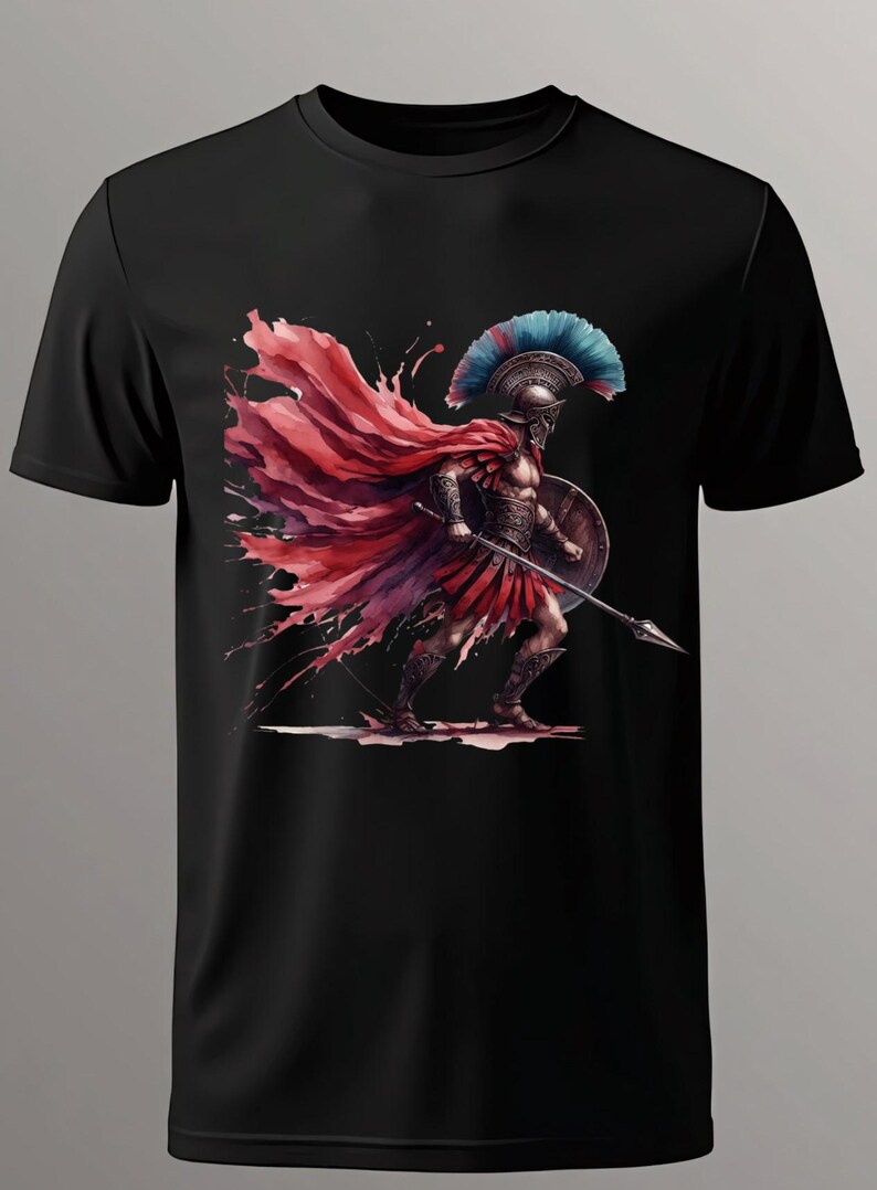 May include: Black t-shirt featuring a watercolor illustration of a Spartan warrior. The warrior is depicted in armor, holding a spear and shield, with a red cape and a blue and red plumed helmet. The design has a dynamic, artistic style.