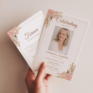 Può includere: Due biglietti commemorativi color crema con accenti floreali e testo dorato. Un biglietto recita "Forever" e l'altro presenta una foto e le parole "Celebrating the Life of Veronica Cooper". I biglietti sono tenuti in mano.