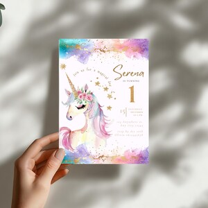 Puede incluir: Una invitaci&oacute;n de cumplea&ntilde;os con un dise&ntilde;o de unicornio en acuarela. La invitaci&oacute;n presenta el nombre "Serena" y el n&uacute;mero "1" en dorado, con los detalles del evento debajo. El fondo tiene salpicaduras de acuarela turquesa, morada y dorada.