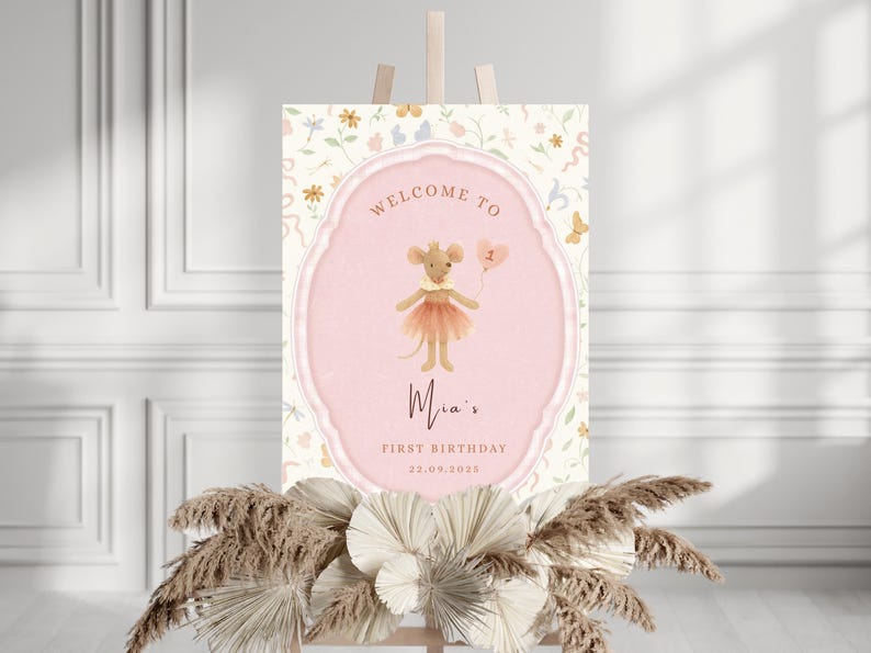 May include: A pink and cream-colored birthday sign featuring a cartoon mouse holding a balloon. The sign reads "Welcome to Mia's First Birthday 22.09.2025" in elegant script. The sign is decorated with floral and butterfly motifs.