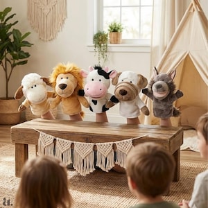May include: A collection of five plush animal hand puppets: a sheep, lion, cow, dog, and wolf. The puppets are arranged on a wooden table, with children in the foreground. The puppets have detailed features and are in a room with natural light.