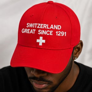 Cappellino "Svizzera Grande dal 1291", rosso ricamato, con toppa della bandiera svizzera, regalo umoristico a tema politico.