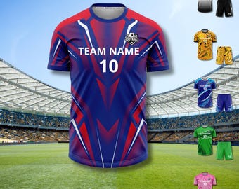May include: A blue and red soccer jersey with the text "TEAM NAME 10" and a soccer ball graphic. Additional jerseys in white, gold, blue, green, and pink are also shown, each with matching shorts. The jerseys are displayed against a stadium backdrop.