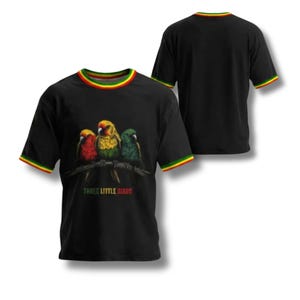 以下が含まれることがあります： 枝にとまった3羽のカラフルな鳥のグラフィックと「THREE LITTLE BIRDS」という文字が描かれた黒の半袖Tシャツ。襟と袖口には赤、黄、緑のストライプがあしらわれています。