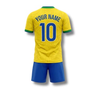 May include: A yellow soccer jersey and blue shorts set. The jersey has the number 10 in blue, with the words "YOUR NAME" above it. The jersey has green and blue trim.