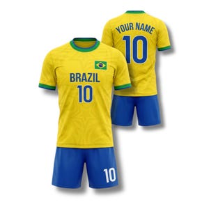 May include: A yellow and blue Brazil soccer uniform. The jersey has the word "BRAZIL" and the number "10" printed on the front. The back of the jersey has the words "YOUR NAME" and the number "10". The shorts are blue.