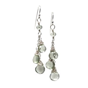 May include: Silver dangle earrings with multiple green gemstone drops.
