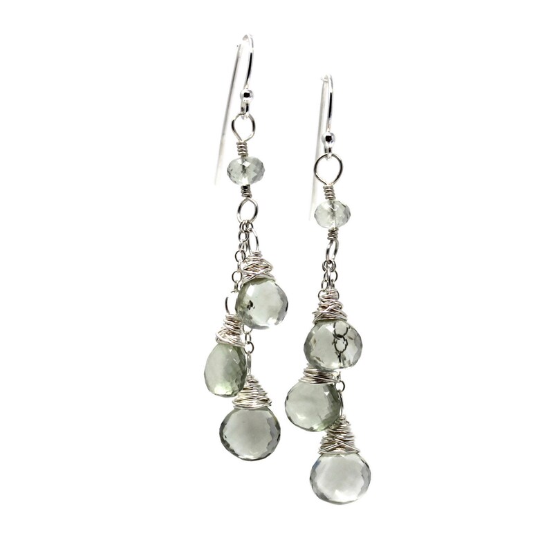 May include: Silver dangle earrings with multiple green gemstone drops.