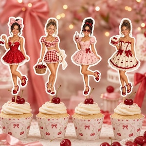 May include: Four cupcakes with white frosting and cherry-themed paper liners, each topped with a decorative cutout of a person in a different outfit. The cutouts feature cherry motifs, including a red dress, a red gingham set, a pink dress, and a cream dress.
