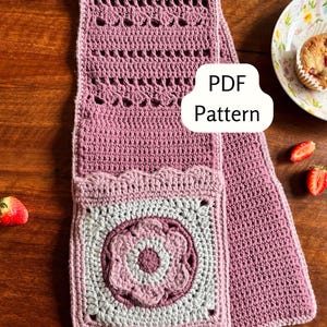 Pode incluir: Cachecol de crochê feito à mão em tons de malva e cinza, com um bolso quadrado com um design floral. O cachecol tem um padrão texturizado e o texto "PDF Pattern" é visível.