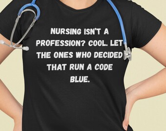 May include: Black t-shirt with the text "NURSING ISN'T A PROFESSION? COOL. LET THE ONES WHO DECIDED THAT RUN A CODE BLUE." A blue stethoscope is around the neck.