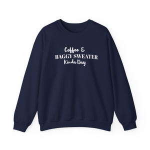 May include: A navy blue sweatshirt featuring the white text "Coffee & Baggy Sweater Kinda Day". This casual crew neck sweater has long sleeves and is suitable for relaxed wear or everyday use.