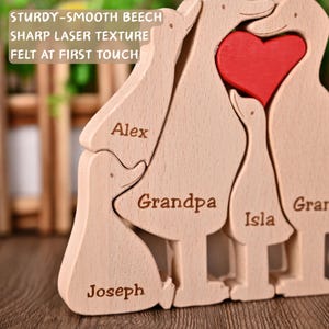 May include: A wooden family puzzle with a red heart at the centre. The light brown puzzle pieces are engraved with names such as "Alex", "Grandpa", "Isla", and "Joseph". The text "STURDY-SMOOTH BEECH" is visible.