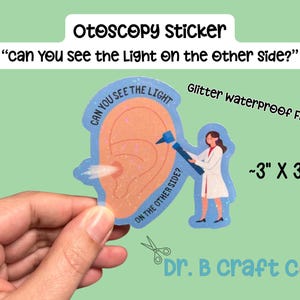 May include: A glitter waterproof otoscopy sticker, approximately 3" x 3", featuring an ear illustration with the text "Can you see the light on the other side?" and a doctor using an otoscope. The sticker is from Dr. B craft co.
