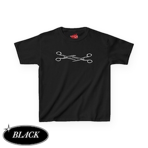 May include: Black t-shirt featuring a white graphic of two crossed scissors. The shirt has short sleeves and a crew neck. The word "BLACK" is in a black oval at the bottom left.