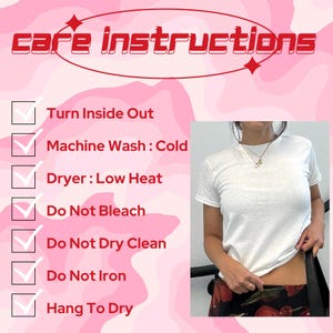 May include: A white crew neck t-shirt with care instructions in a pink and red design. The instructions include turning the shirt inside out, machine washing cold, low heat drying, and avoiding bleach, dry cleaning, and ironing. The shirt is shown being worn.