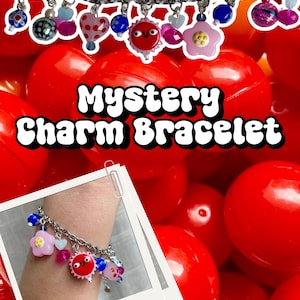 Könnte beinhalten: Ein silbernes Charm-Armband mit bunten Anhängern, darunter eine rosa Blume, eine rote Sonne und blaue Perlen. Das Bild zeigt den Text "Mystery Charm Bracelet" in fetter, weißer Schrift. Der Hintergrund ist mit roten Plastikkugeln gefüllt.
