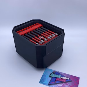May include: A black, octagonal tool organizer with a red interior holding multiple screwdrivers. The screwdrivers have black handles and red accents. A business card with the text "dennis smallbone prints" is in the foreground.