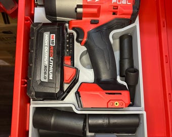 Könnte beinhalten: Ein roter und schwarzer Milwaukee FUEL Schlagschrauber mit Akku und Steckschlüsseln in einer roten Werkzeugkiste. Der Akku ist mit "M18 REDLITHIUM HIGH OUTPUT XC6.0" beschriftet. Das Milwaukee-Logo ist deutlich sichtbar.