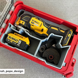 May include: A red, rectangular tool case with a clear lid, containing a yellow and black oscillating multi-tool, a battery, and various attachments. The case is labeled with the brand "DEWALT".