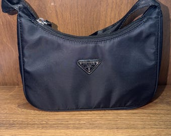 Black purse with triangular logo for woman