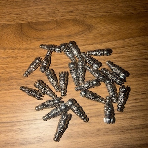 May include: A set of three ceramic mugs with a speckled, matte finish. The mugs are in shades of cream, light gray, and dark gray. Each mug has a simple, minimalist design and a rounded handle.