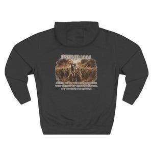 May include: Dark gray hoodie with a hood. The back features an image of a battle scene with text that reads "PSALM 144:1" and "PRAISE BE TO THE LORD MY ROCK, WHO TRAINS MY HANDS FOR WAR, MY FINGERS FOR BATTLE."