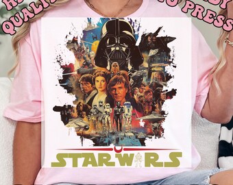 May include: Pink t-shirt featuring a colorful Star Wars graphic with Darth Vader, Luke Skywalker, and other characters. The words "HIGH QUALITY", "READY TO PRESS", and "DTF TRANSFERS" are printed on the shirt.