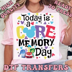 May include: A light pink t-shirt with a colorful graphic that reads "Today is a CORE MEMORY Day." The design includes cartoon characters and Mickey Mouse ears. The words "HIGH QUALITY" and "READY TO PRESS" are also visible.