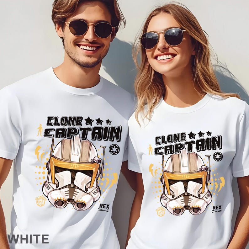 May include: White t-shirts with a "Clone Captain" graphic featuring a helmet design in shades of tan, white, and black. The text "REX" is below the helmet. The shirts have the word "WHITE" at the bottom.