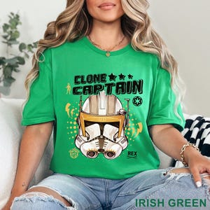 May include: A green t-shirt with the text "CLONE CAPTAIN" and a graphic of a white and gold helmet. The shirt also has the text "REX" and "IRISH GREEN".