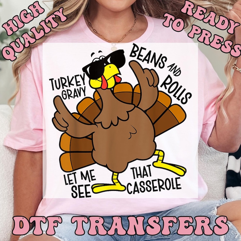 Puede incluir: Una camiseta blanca con una ilustraci&oacute;n de un pavo de dibujos animados con gafas de sol y gesticulando con sus alas. El texto incluye "Turkey Gravy", "Beans and Rolls", "Let Me See" y "That Casserole". Tambi&eacute;n est&aacute;n las palabras "High Quality", "Ready to Press" y "DTF Transfers".