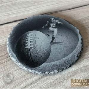 May include: A grayscale, circular coaster featuring a football and a football player kicking the ball. The player wears the number 10. The coaster has a rough, textured edge. The words "DIGITAL DOWNLOAD" are visible.