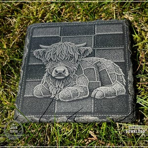 May include: A square, dark gray slate coaster featuring a detailed engraved image of a Highland cow. The cow is lying down on a patchwork pattern. The words "LASER TESTED" and "DIGITAL DOWNLOAD" are also visible.