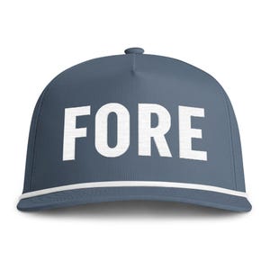 Peut inclure: Une casquette de baseball bleu ardoise avec le mot FORE en lettres capitales blanches audacieuses sur le panneau avant. La casquette comprend une bordure en cordon tressé blanc courant horizontalement à la base de la calotte, au-dessus de la visière.