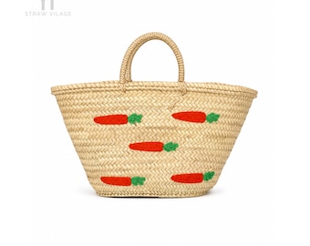 May include: A woven straw basket bag featuring two top handles and a repeating pattern of embroidered orange carrots with green tops. The text YT STRAW VILAGE is printed in the upper left corner of the image against a plain white background.