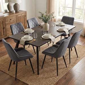 Puede incluir: Un comedor moderno con una mesa de madera oscura y seis sillas grises. Las sillas tienen un patrón de diamantes en los respaldos. La mesa está puesta con vajilla blanca, cubiertos dorados y copas. Un jarrón con vegetación está en el centro.