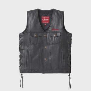 Puede incluir: Chaleco de cuero negro con cuello en V, con dos bolsillos en el pecho y dos bolsillos inferiores. El chaleco tiene una parte delantera abotonada y laterales con cordones. El logotipo de Indian Motorcycle es visible en rojo en el pecho.