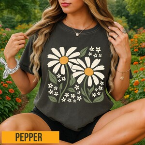 a woman sitting in a field of flowers