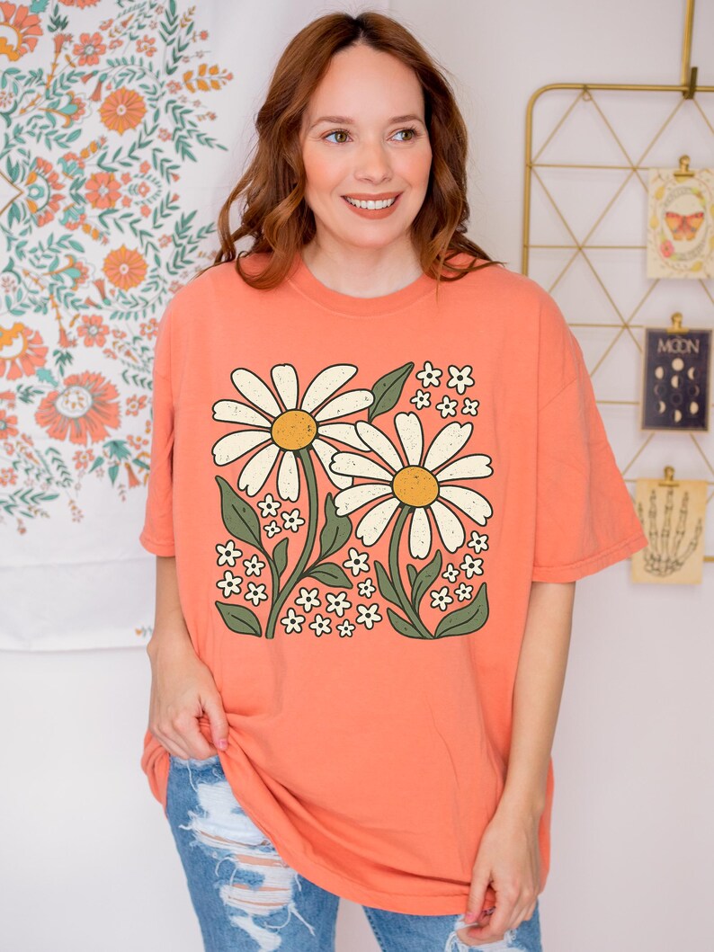 a woman standing in front of a wall with flowers on it
