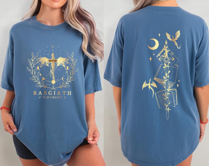a woman wearing a blue t-shirt with a design featuring a dragon, a crescent moon, and a cross. The design is gold-colored and appears to be a symbol or emblem associated with the "Bagith" brand.